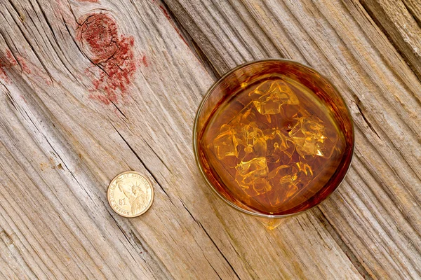 Un verre de whisky et une pièce sur un comptoir — Photo