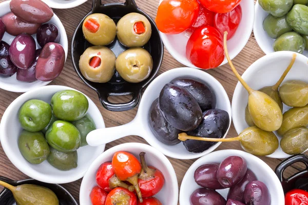 Colorful assortment of cured olives and peppers — Stock Photo, Image