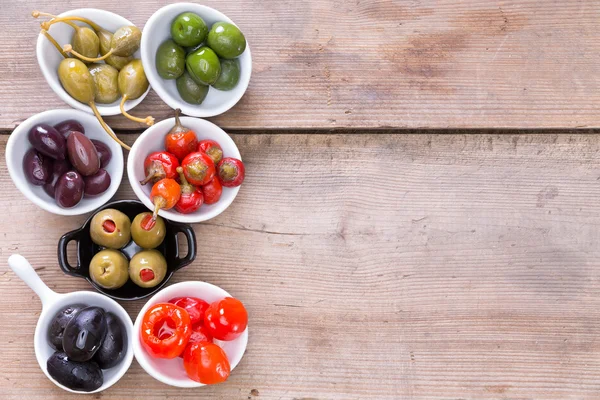Assortment of cured olives and peppers — Stock Photo, Image