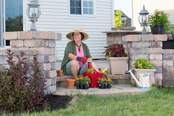 Feliz abuela plantando en su jardín — Foto de Stock