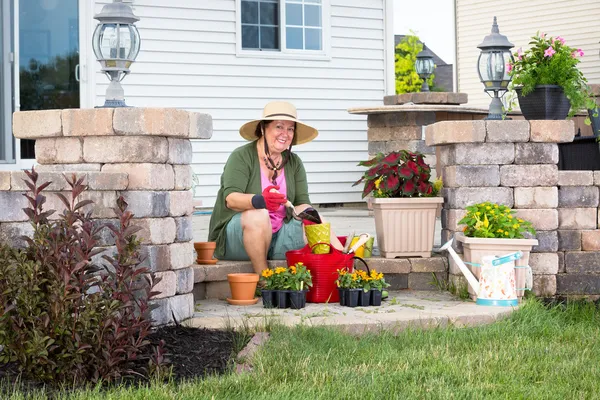Happy elderly Grandma potting up plants — Stock Photo, Image