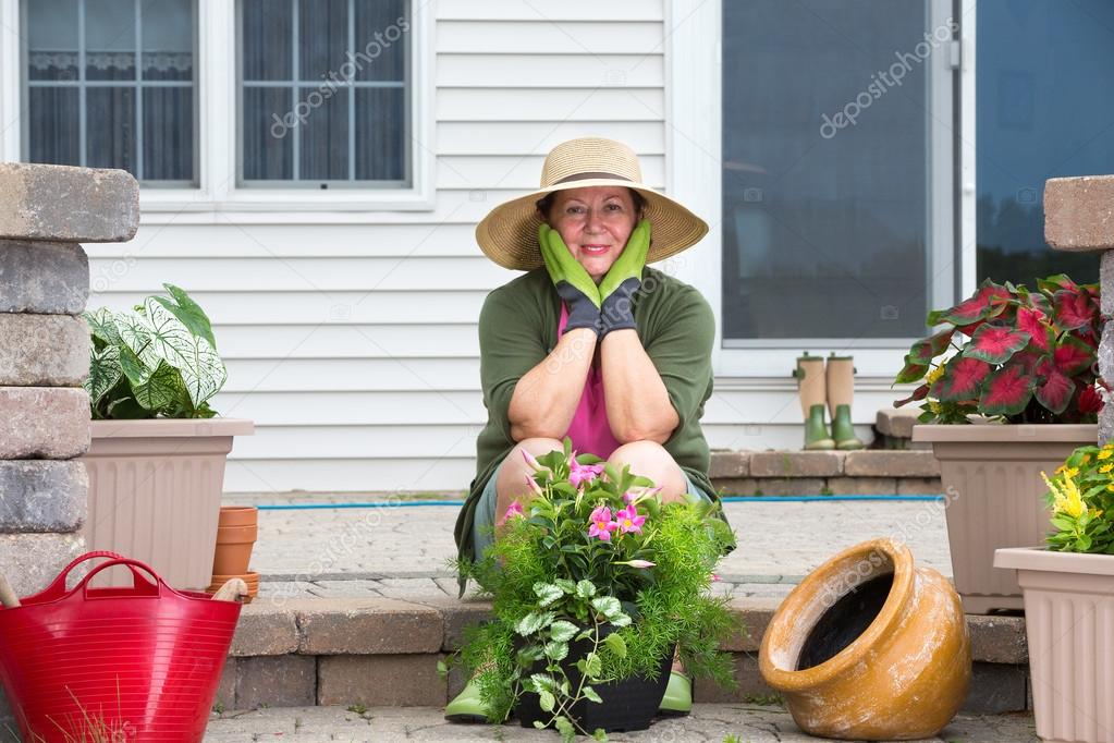 Elderly woman pausing while potting up plants