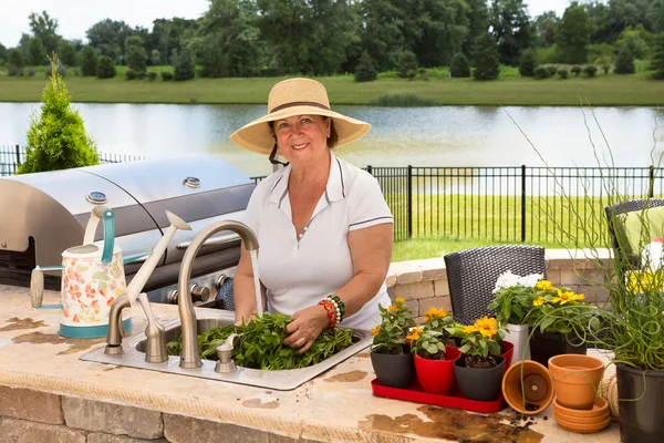 Grandmother caring for her potted plants — Stock Photo, Image