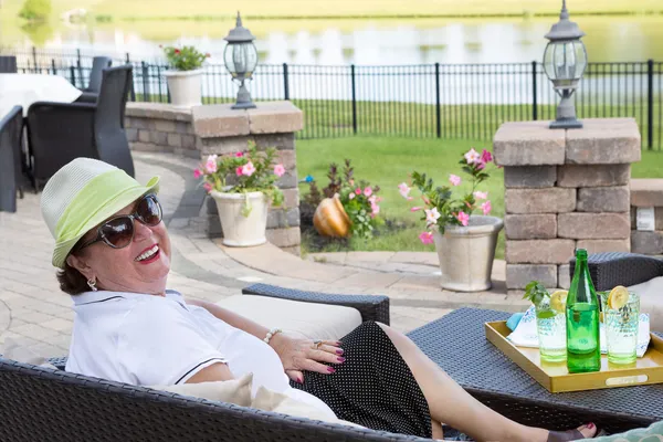 Senior vrouw genieten van een drankje op het terras — Stockfoto