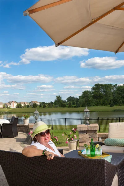 Femme âgée se détendre sur un patio extérieur en brique — Photo