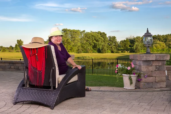 Senior senhora assistindo o pôr do sol a partir do pátio — Fotografia de Stock