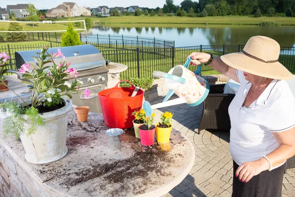 Senior lady watering her newly potted plants — Stock Photo, Image