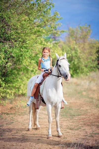 女学生骑着一匹白色的小马 那孩子骑着马 儿童骑马训练 用缰绳控制马 — 图库照片