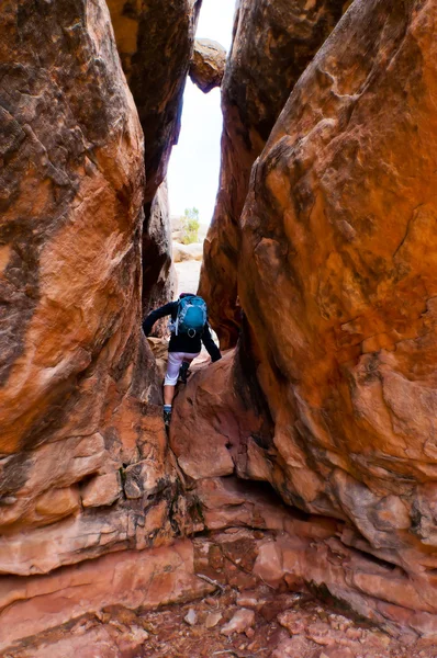 Hiker under boulder — Stock Photo, Image