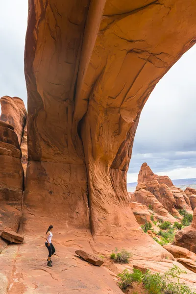 Kvinnliga vandrare under tornet arch trail — Stockfoto