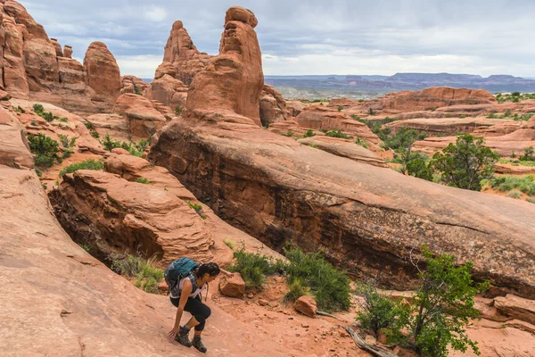 Kvinnliga vandrare under tornet arch trail — Stockfoto