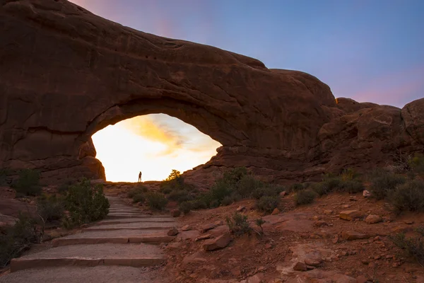 Chica excursionista stading en North Window Arch al amanecer — Foto de Stock