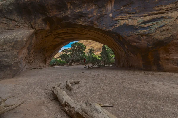 Female hiker standing under Navajo Arch — Stock Photo, Image