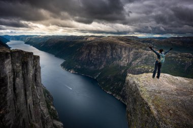 Zafer pozu veren sırt çantalı, Kjeragbolten yakınlarında Eagle Head Viewpoint 