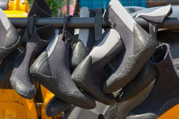 Wet suit boots hanging on a rack. — Stock Photo, Image