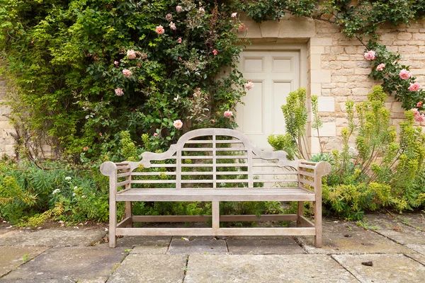 Weathered garden bench in landscaped setting — Stock Photo, Image