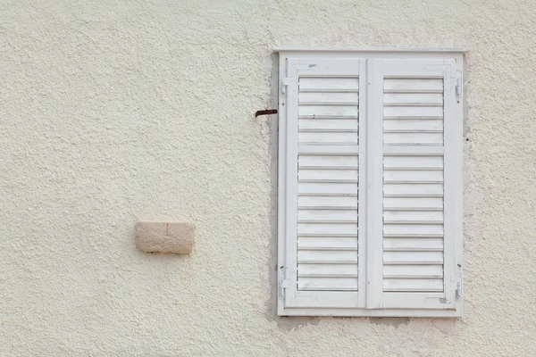 Fenêtre en bois blanc avec volets à lattes fermés — Photo