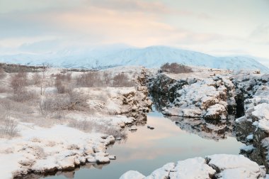 Thingvellir National Park Iceland snow covered mountains and rocky terrain clipart