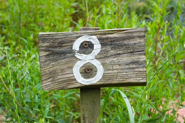 Дерев'яний знак, що дає номер ділянки саду — стокове фото