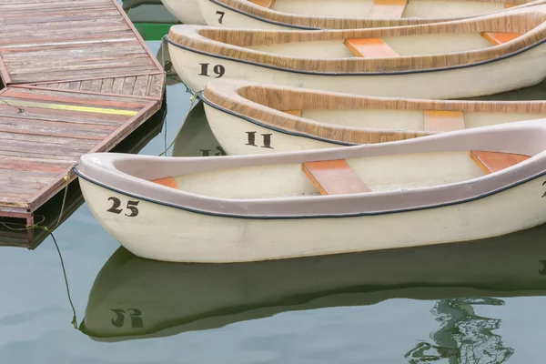 Пронумерованные весельные лодки, привязанные к озеру — стоковое фото