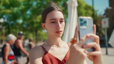 Yakın plan genç bir kadın selfie çekiyor, limanda otururken çekilmiş bir video, cep telefonu kullanıyor. Gülümseyen kız, sosyal medyayı kullan, arka plandaki yat ve gemilerde yayın hizmetini kullan