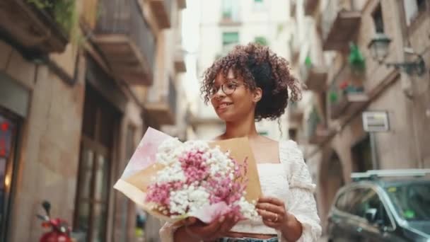 Wanita Muda Berkacamata Berjalan Dengan Karangan Bunga Sepanjang Jalan Pusat — Stok Video