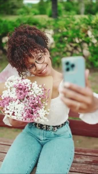 Vertisk Video Ung Kvinna Tar Selfie Med Bukett Blommor Parken — Stockvideo