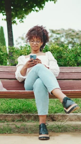 Parktaki Bankta Elinde Akıllı Bir Telefonla Oturan Genç Bir Kadının — Stok video