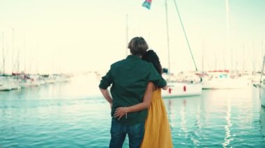 Limanda duran mutlu ırklar arası çiftin yakın çekimi. Yakın plan, yatta sarılan genç kadın ve erkek. arka plan