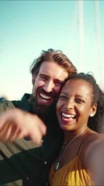 Mutlu bir adamın ve gülümseyen bir kadının akıllı telefondan yaptığı portreyi yakından çek. Yakın plan, neşeli, ırklar arası iletişim kuran çift cep telefonu kullanıyor.