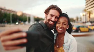 Şehirler arası gülümseyen bir çiftin şehir geçmişinde selfie çekerken çekilmiş yakın plan portresi. Yakın plan, erkek ve kadın cep telefonu kullanarak görüntülü sohbet.