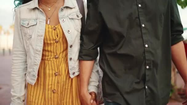 閉じると 男と女の手を握って笑みを浮かべて歩いてください 街の通りに行く愛の若い異人種間のカップルのクローズアップ — ストック動画