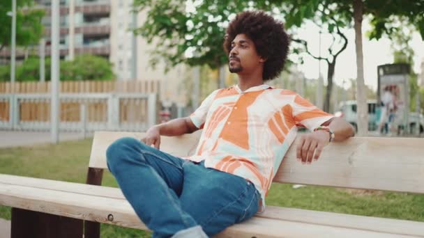 Close Jovem Afro Americano Vestindo Camisa Sentado Relaxado Banco Parque — Vídeo de Stock