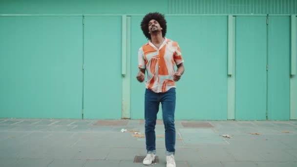 Tişört Giyen Kablosuz Kulaklıkla Müzik Dinleyen Açık Mavi Duvar Arkasında — Stok video