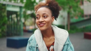 Kot ceketli, güzel, Afro-Amerikan bir kadının giysisi. Etrafa bakıyor. Yavaş çekim