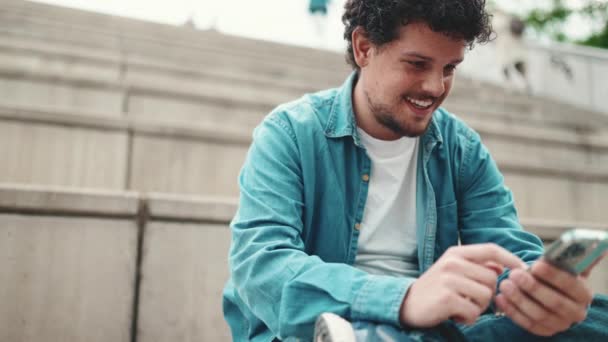 Retrato Close Jovem Homem Barbudo Sorridente Camisa Jeans Sentado Degraus — Vídeo de Stock