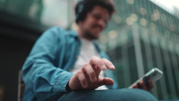 Zbliżenie Ręki Młodego Brodatego Mężczyzny Dżinsowej Koszuli Siedzącego Słuchawkach Słuchającego — Wideo stockowe