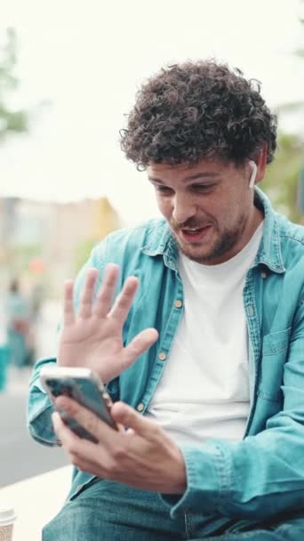 Video Vertical Joven Barbudo Con Camisa Vaquera Sentado Auriculares Inalámbricos — Vídeos de Stock