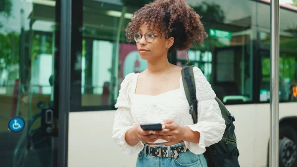 Młoda Kobieta Okularach Gapiąca Się Smartfona Stojąc Przystanku Autobusowym Pozytywna — Zdjęcie stockowe