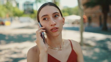 Şirin genç bir bayan sokakta cep telefonu kullanıyor. Kız eski şehrin arka planında bir bankta oturuyor ve akıllı bir telefonla konuşuyor.