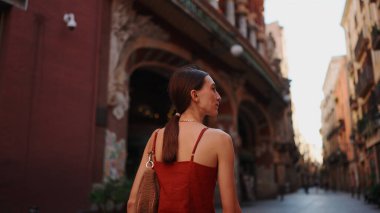 Güzel genç bir kadın caddede yürüyor ve etrafı geziyor. Kız şehir merkezinde dar bir cadde boyunca gider ve etrafa dikkatlice bakar..