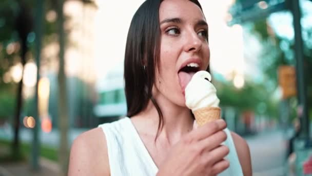 特写美丽的女人 有雀斑和深色宽松的头发 头戴白色的顶部测试冰淇淋 可爱的女孩喜欢现代都市背景的冰淇淋 — 图库视频影像