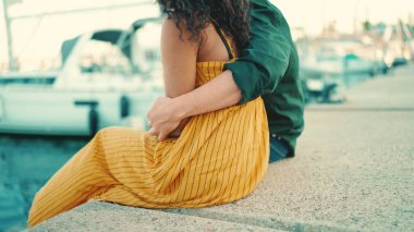 Yakından, bir erkek bir kadına sarılır ve elini sıvazlar. Mutlu ırklar arası çiftlerin yakın çekimleri limandaki yatların arka planında oturuyorlar..