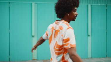 Açık mavi duvar arka planında kameraya gülümseyen, gömlekli, neşeli, Afro-Amerikan bir adamın yakın plan portresi. Yaşam tarzı kavramı. 