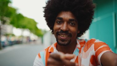 Açık mavi duvar arka planında kameraya gülümseyen, gömlekli, neşeli, Afro-Amerikan bir adamın yakın plan portresi. Yaşam tarzı kavramı. 