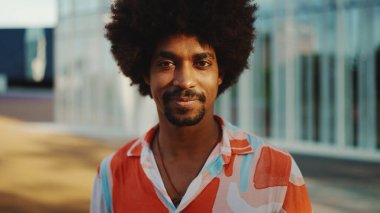 Kentin arka planında duran, gülümseyen, Afro-Amerikan gömlekli genç bir adamın yakın plan portresi. Yaşam tarzı kavramı. 