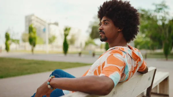 Närbild Unga Afroamerikanska Mannen Bär Skjorta Sitter Avslappnad Parkbänken Tittar — Stockfoto