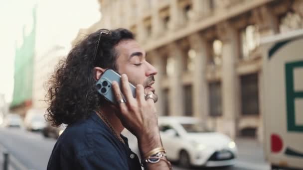 머리가 곱슬곱슬 매력적 이탈리아 핸드폰을 사용하고 있습니다 붐비는 거리에서 스마트폰으로 — 비디오