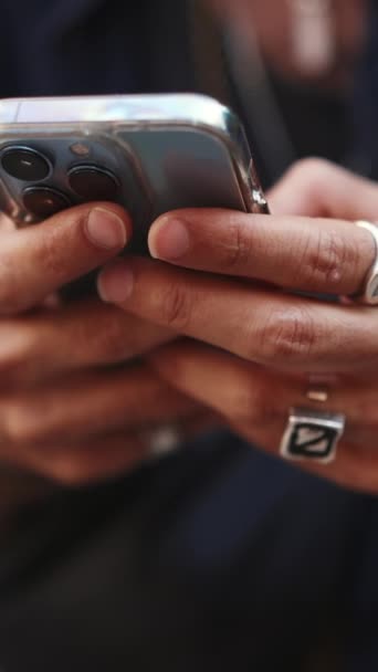 垂直视频 男性手戴着手镯和戒指的特写 男人在用手机 那家伙在他的智能手机上留言 — 图库视频影像