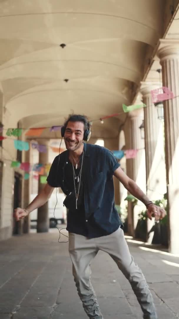 Vertical Video Junger Italiener Mit Pferdeschwanz Und Stoppeln Kopfhörer Geht — Stockvideo